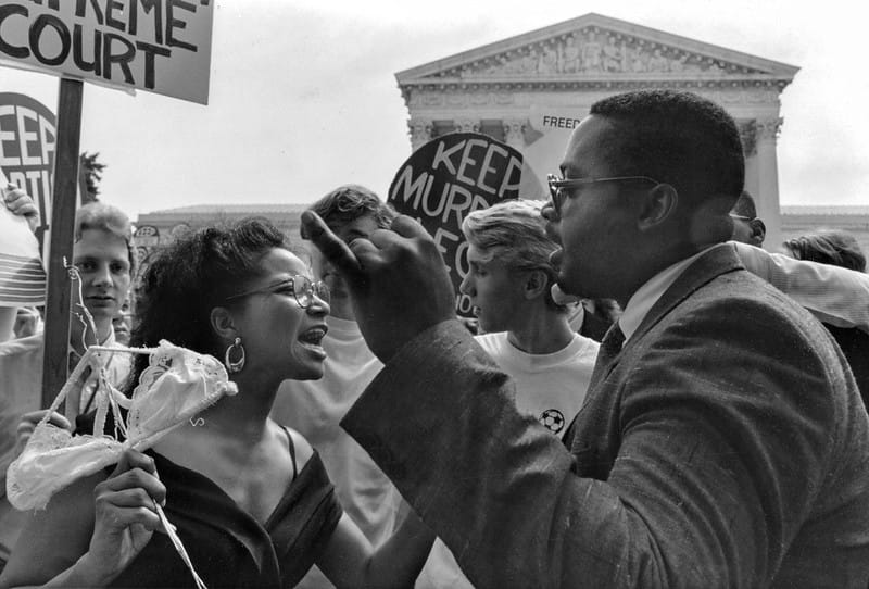 A pro-choice and an anti-abortion demonstrator confront each other outside the Supreme Court in 1989, Washington DC.