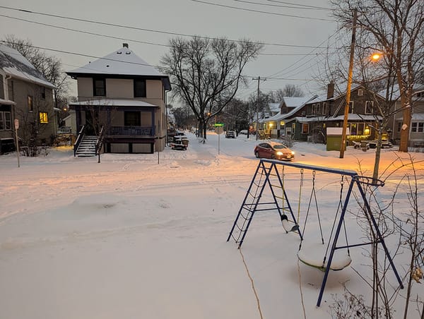 A car turns at a T-junction on a snowy evening in Madison, Wisconsin.